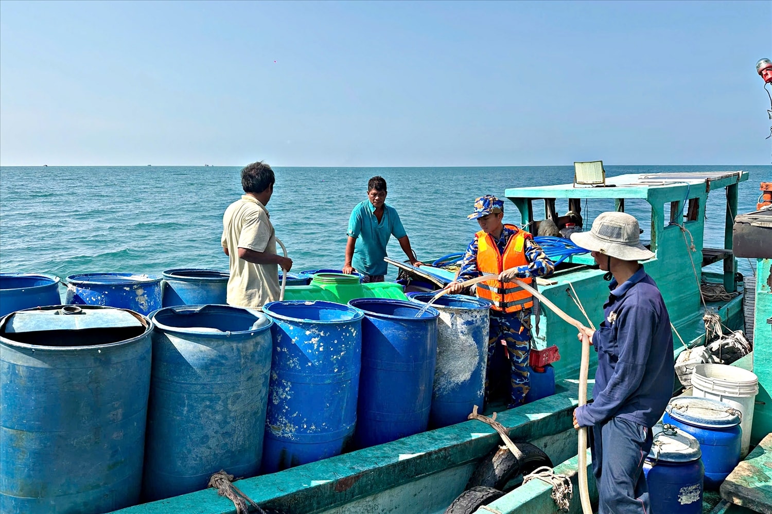 Người dân đảo Hòn Chuối sử dụng thùng phuy vận chuyển nước từ Tàu 527 lên đảo. (Ảnh: Định Thắng)