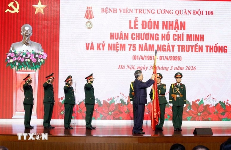 Tổng Bí thư Tô Lâm gắn Huân chương Hồ Chí Minh lên Quân kỳ Quyết thắng của Bệnh viện Trung ương Quân đội 108 - Ảnh: TTXVN