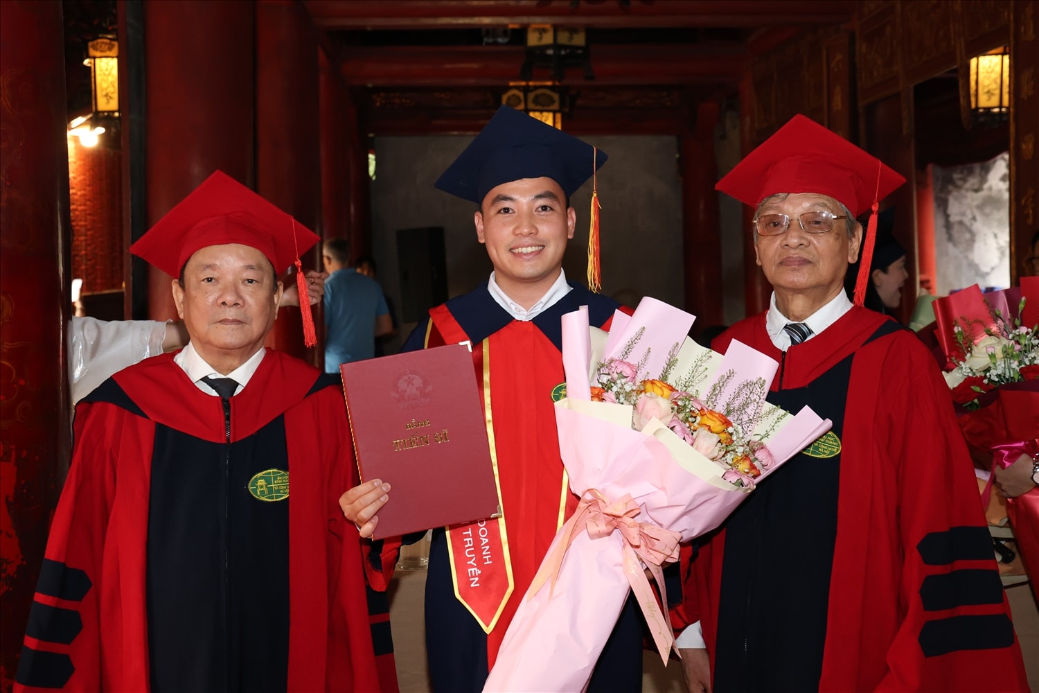 Đại diện Ban Giám hiệu nhà trường trao bằng tiến sỹ cho nghiên cứu sinh