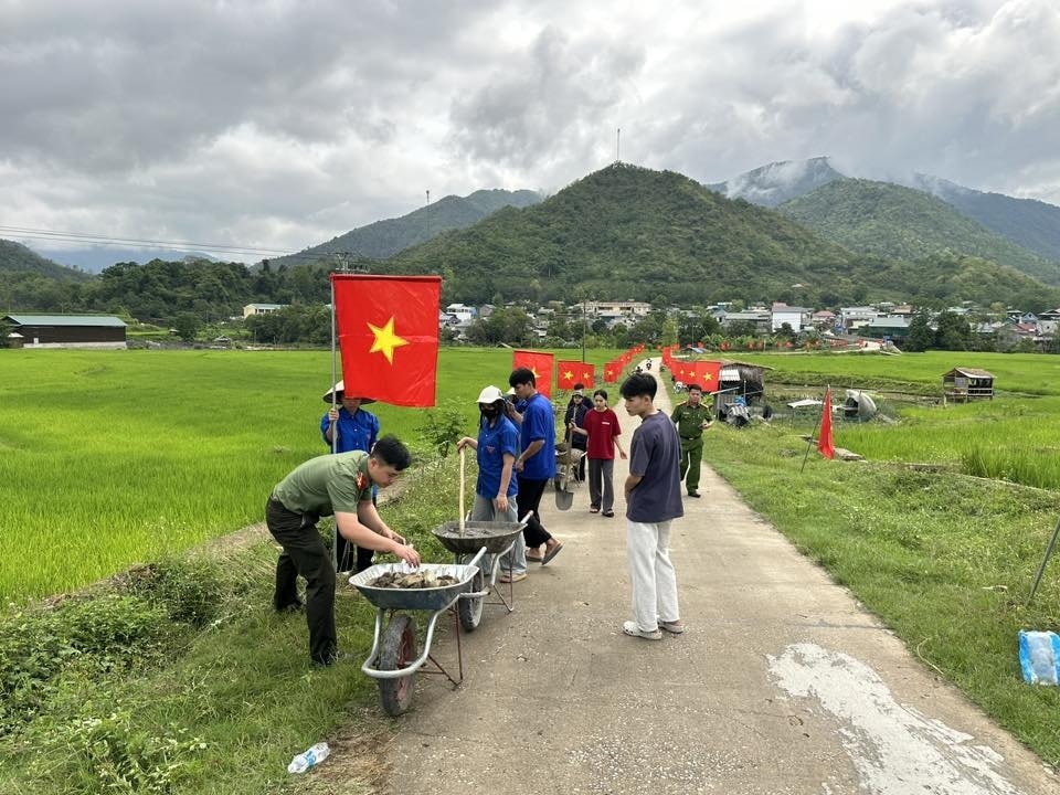 Công an xã Quang Chiểu phối hợp với Nhân dân địa phương dựng cột, treo cờ Tổ quốc dọc tuyến đường vào trung tâm xã.