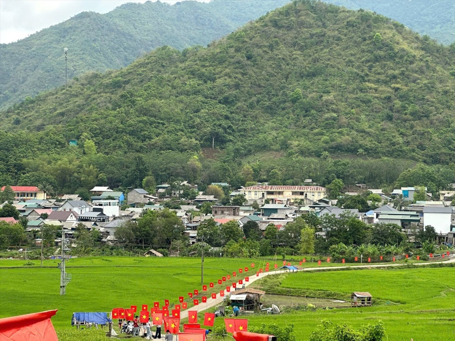 Tuyến “Đường cờ Tổ quốc” uốn dài qua cánh đồng xanh mướt, tạo điểm nhấn rực rỡ cho diện mạo nông thôn xã biên giới Quang Chiểu (Thanh Hóa).
