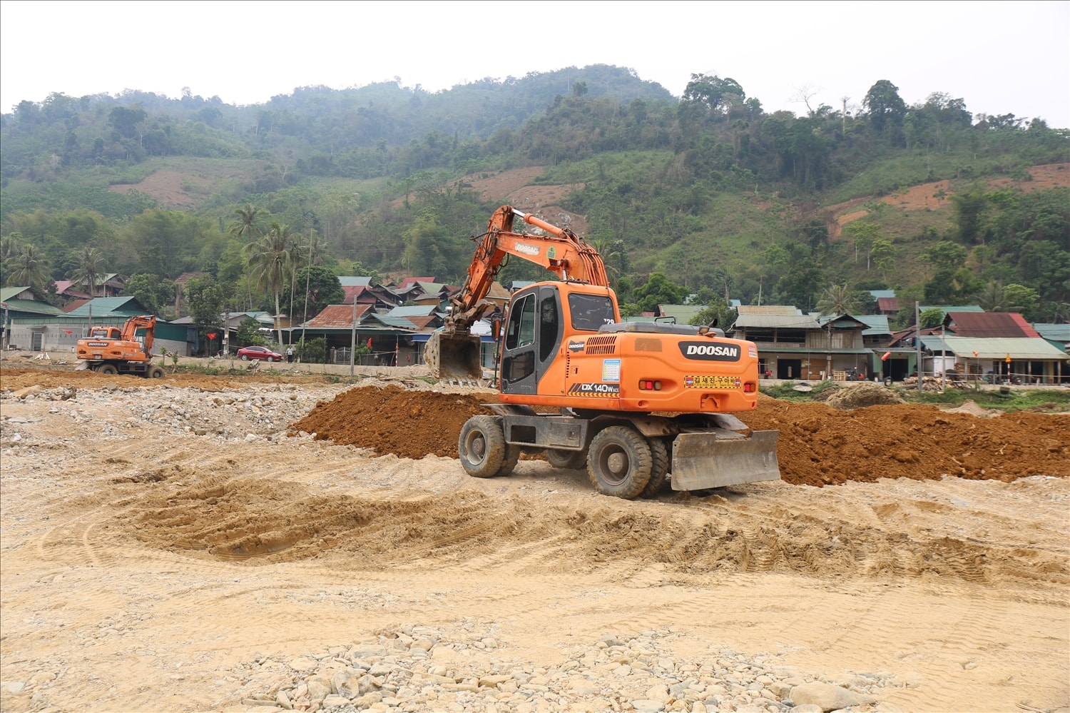 Huy động nhiều máy móc khôi phục lại ruộng sản xuất ở xã Nhôn Mai - Ảnh: T.H