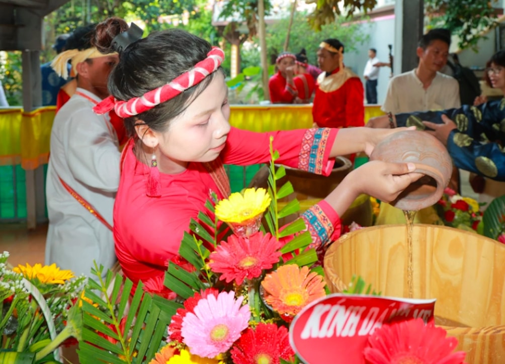 Thiếu nữ Chăm thực hiện nghi thức lấy nước. (Ảnh: T.N)
