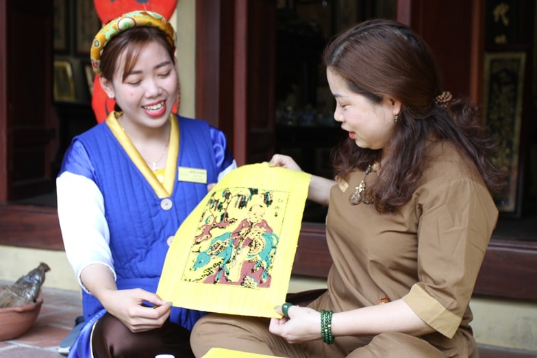 Một du khách trải nghiệm in tranh Đông Hồ