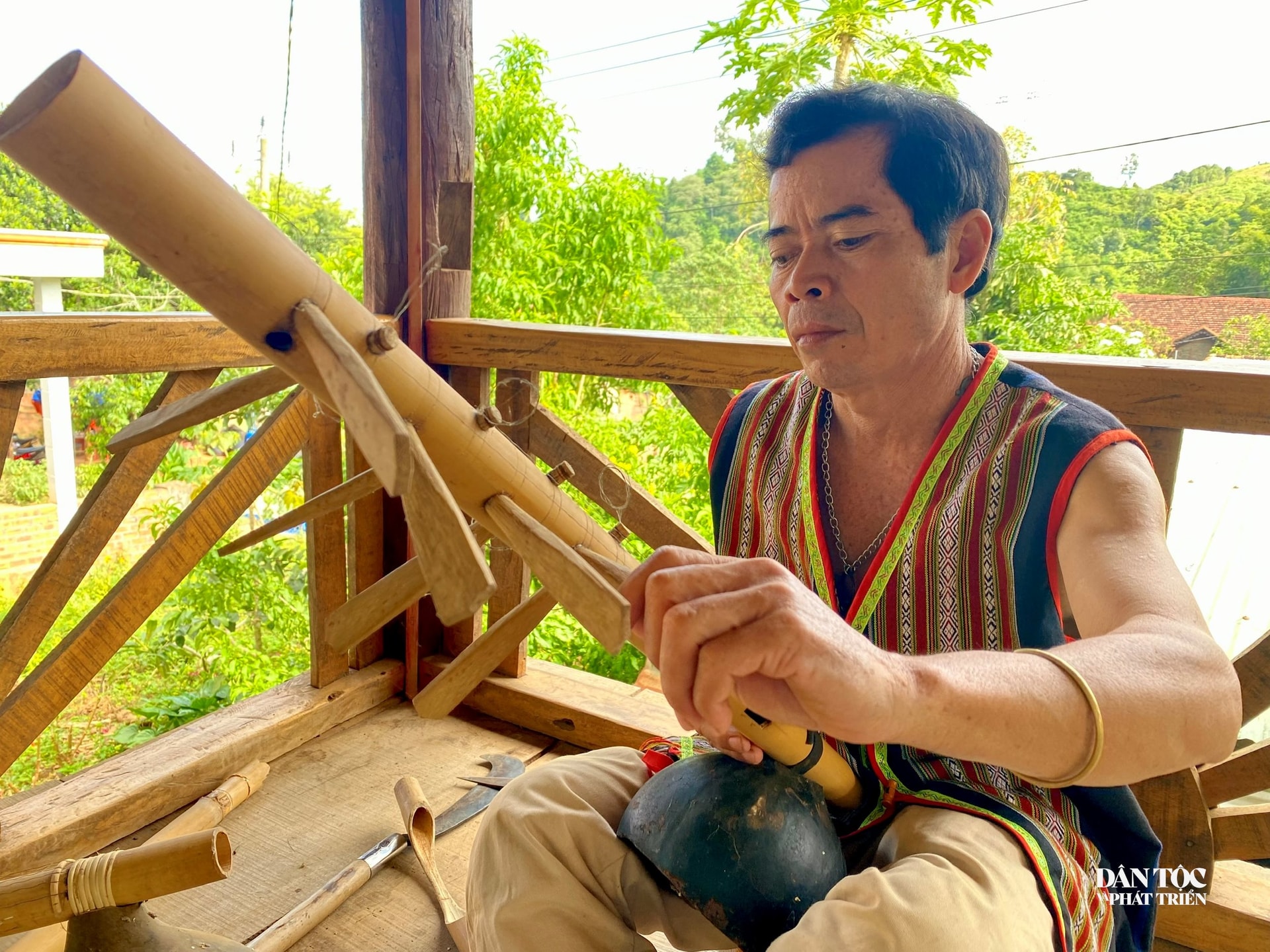 Nghệ nhân A Nhum chỉnh lại đàn ting ning trước khi đàn và hát dân ca. Ảnh: Ngọc Chí