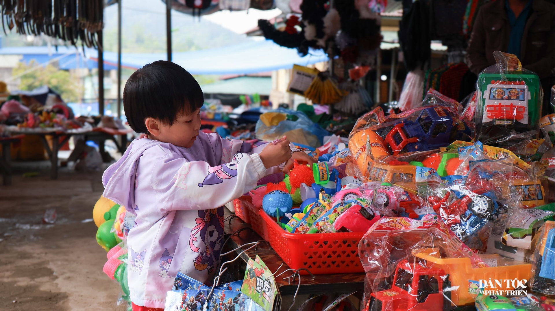 Con trẻ trước những món đồ chơi sắc màu, một nét chấm phá sinh động phản ánh sự giao thoa văn hóa đang hiện hữu nơi lòng bản.