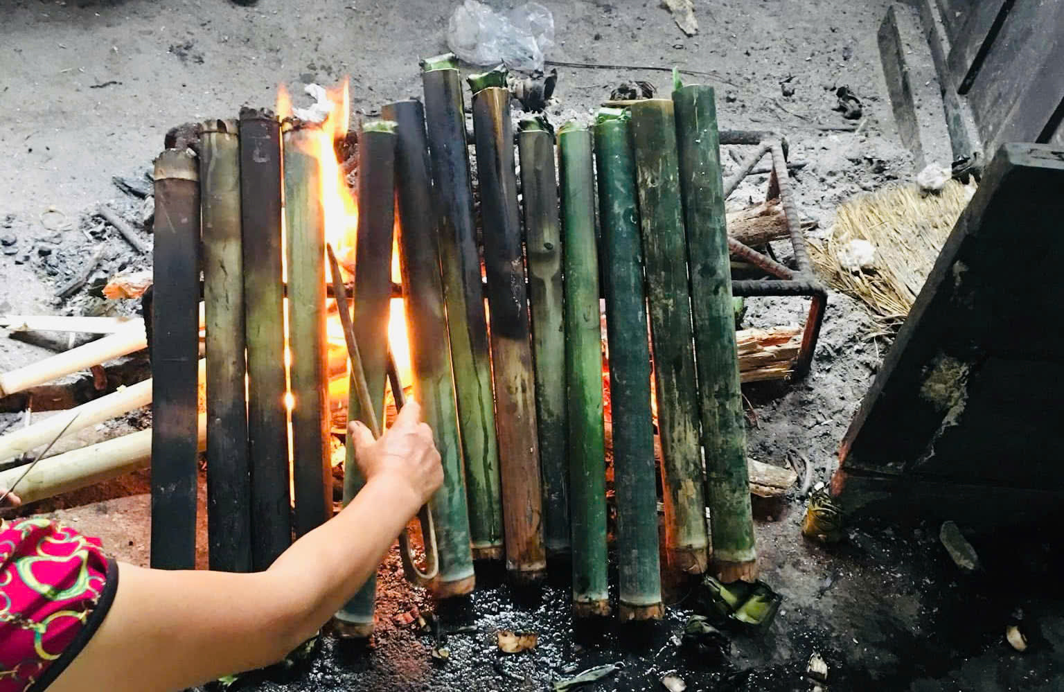 Những ống nứa đựng gạo được nướng lên cho ra thành phẩm cơm lam (Ảnh Việt Hà)