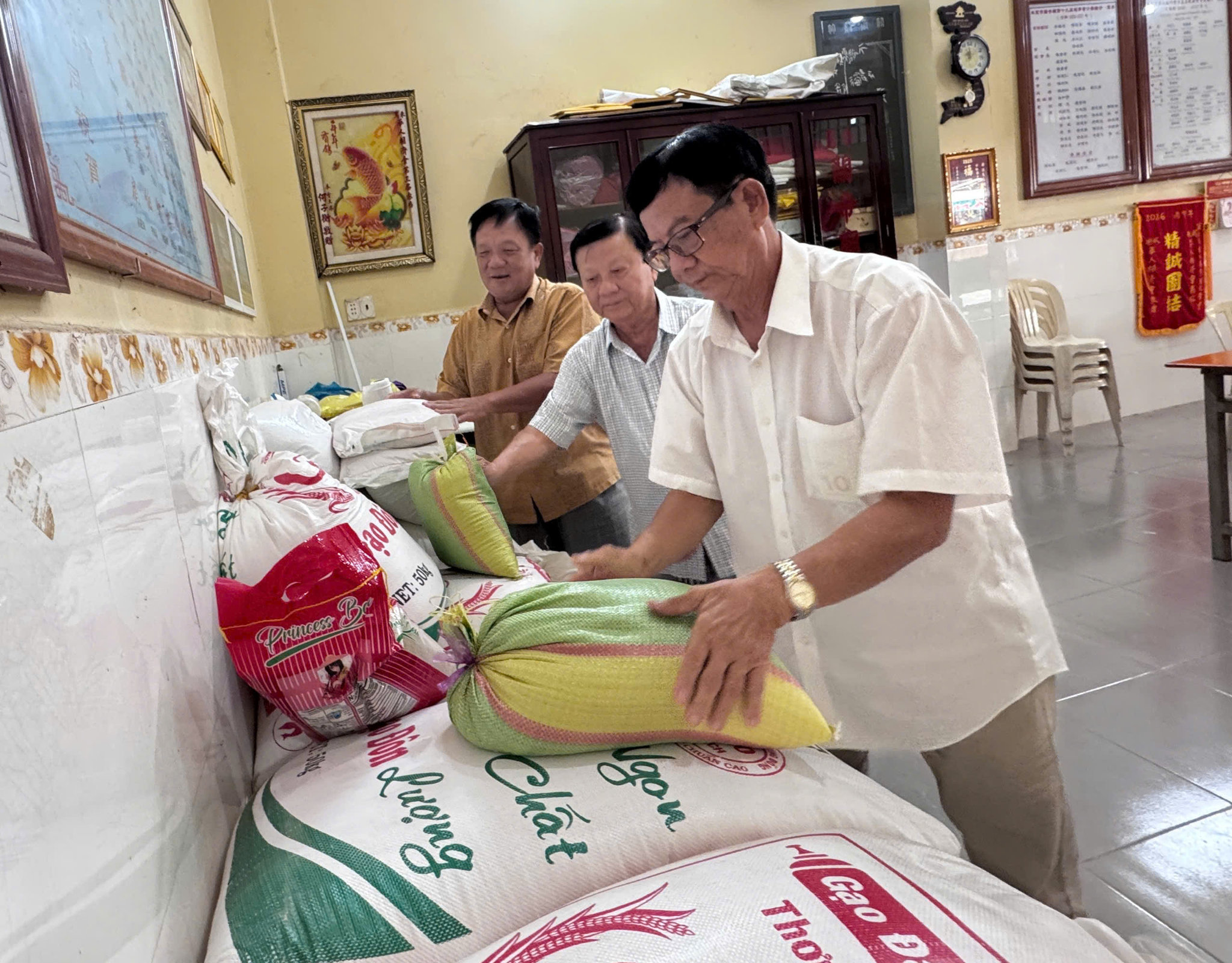 Ông Lai Kim Tường cùng các vị trong Thường trực Hội Tương tế chuẩn bị gạo hỗ trợ định kỳ cho các hộ gia đình có hoàn cảnh khó khăn