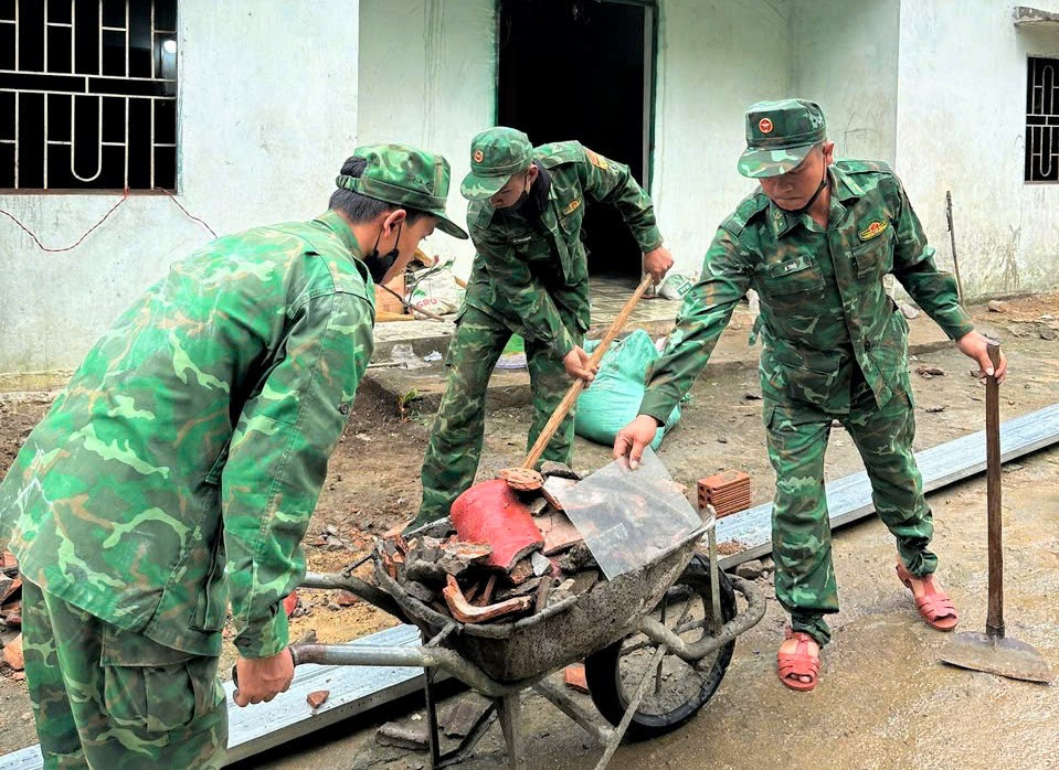 Cán bộ, chiến sĩ Đồn Biên phòng Đăk Blô hỗ trợ ngày công sửa chữa nhà cho bà Y Hà, thôn Đông Nay, xã Đăk Plô. Ảnh: ĐVCC