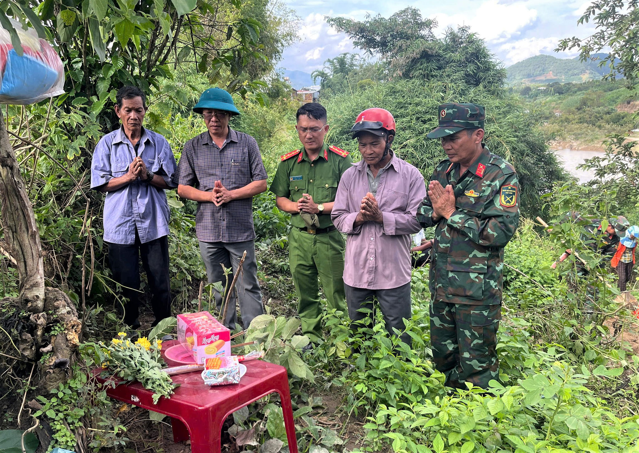 Ông Y Nghe Pang Taih (thứ 2 từ trái qua phải) và ông Y Biêng Ntơr (bìa trái) cùng Đội K51 xác định vị trí an táng liệt sĩ