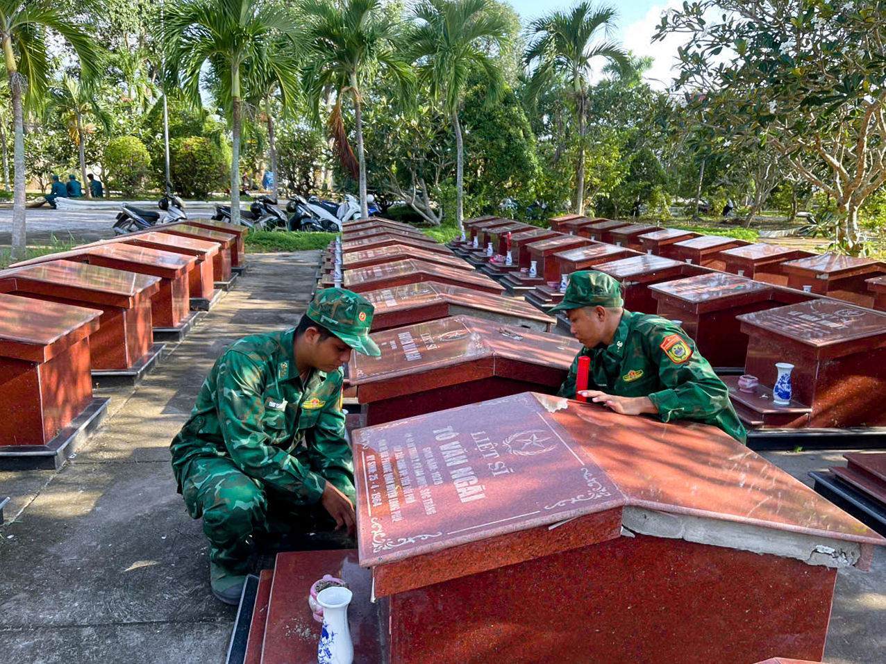 Cán bộ đồn Biên phòng An Thạnh Ba tham gia dọn vệ sinh, chỉnh trang Nghĩa trang Liệt sĩ. Ảnh: Văn Long