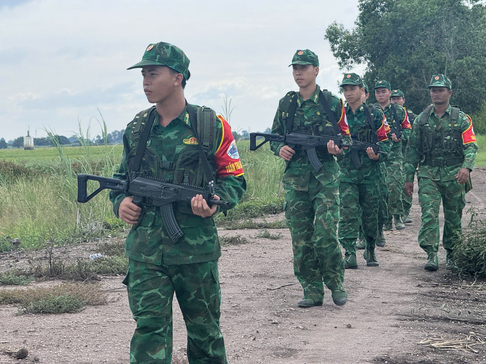 Thượng uý Chau Ranh ( đi bìa phải) - Đội trưởng Vũ trang trao đổi, tuyên truyền cùng bà con cả tiếng Khmer. Ảnh: Như Tâm