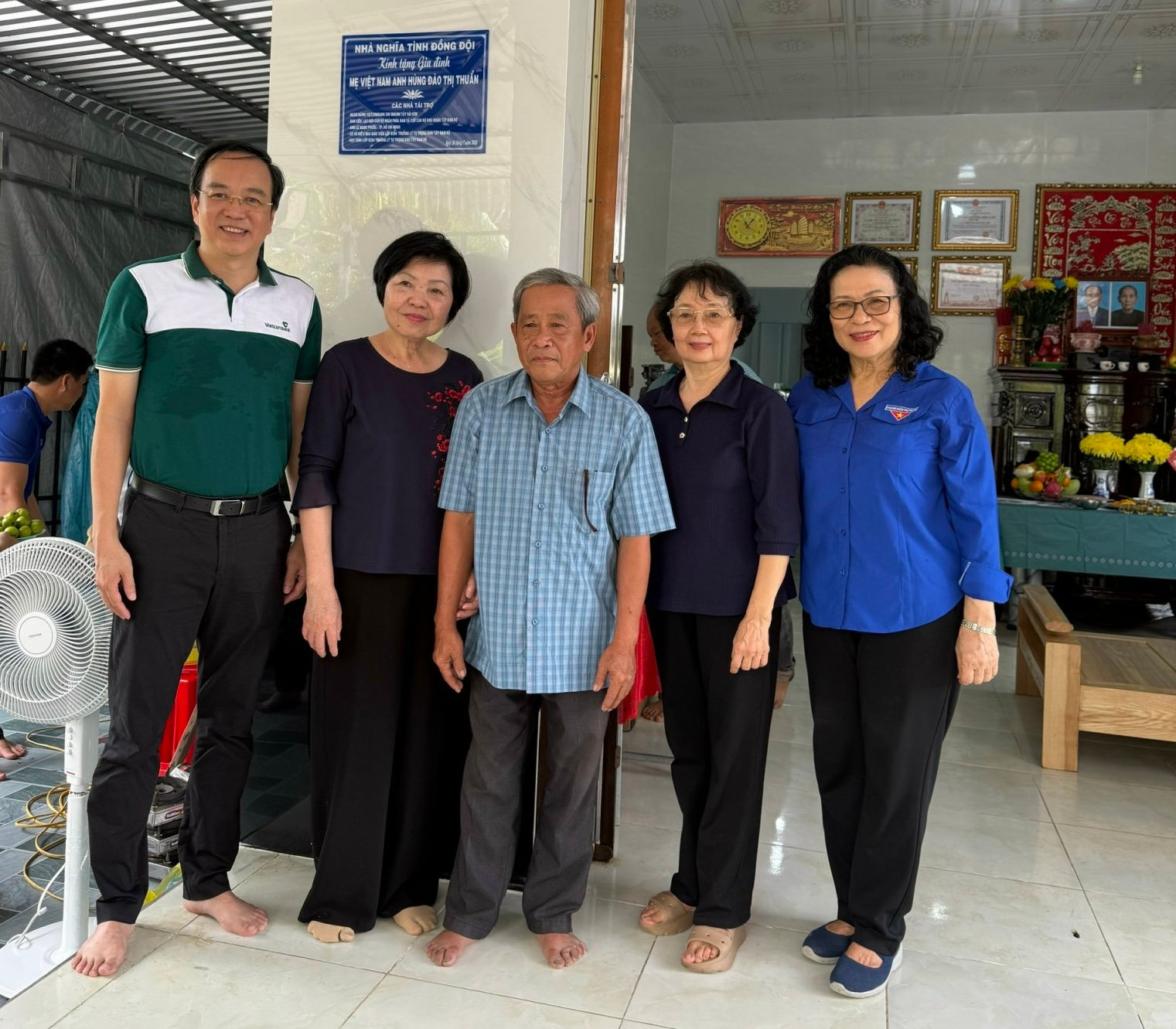 Các nhà tài trợ chụp ảnh lưu niệm cùng ông Trần Việt Trường (Đứng giữa) là người trực tiếp thờ phụng Mẹ Việt Nam Anh hùng Đào Thị Thuẩn và 2 người anh là liệt sĩ