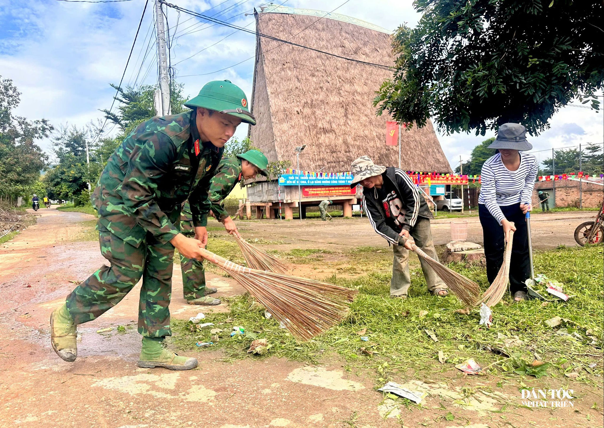Cán bộ, chiến sĩ Trung đoàn Pháo binh 4 giúp Nhân dân thôn Kon Bơ Băn vệ sinh môi trường khuôn viên nhà rông của thôn. Ảnh: Ngọc Chí