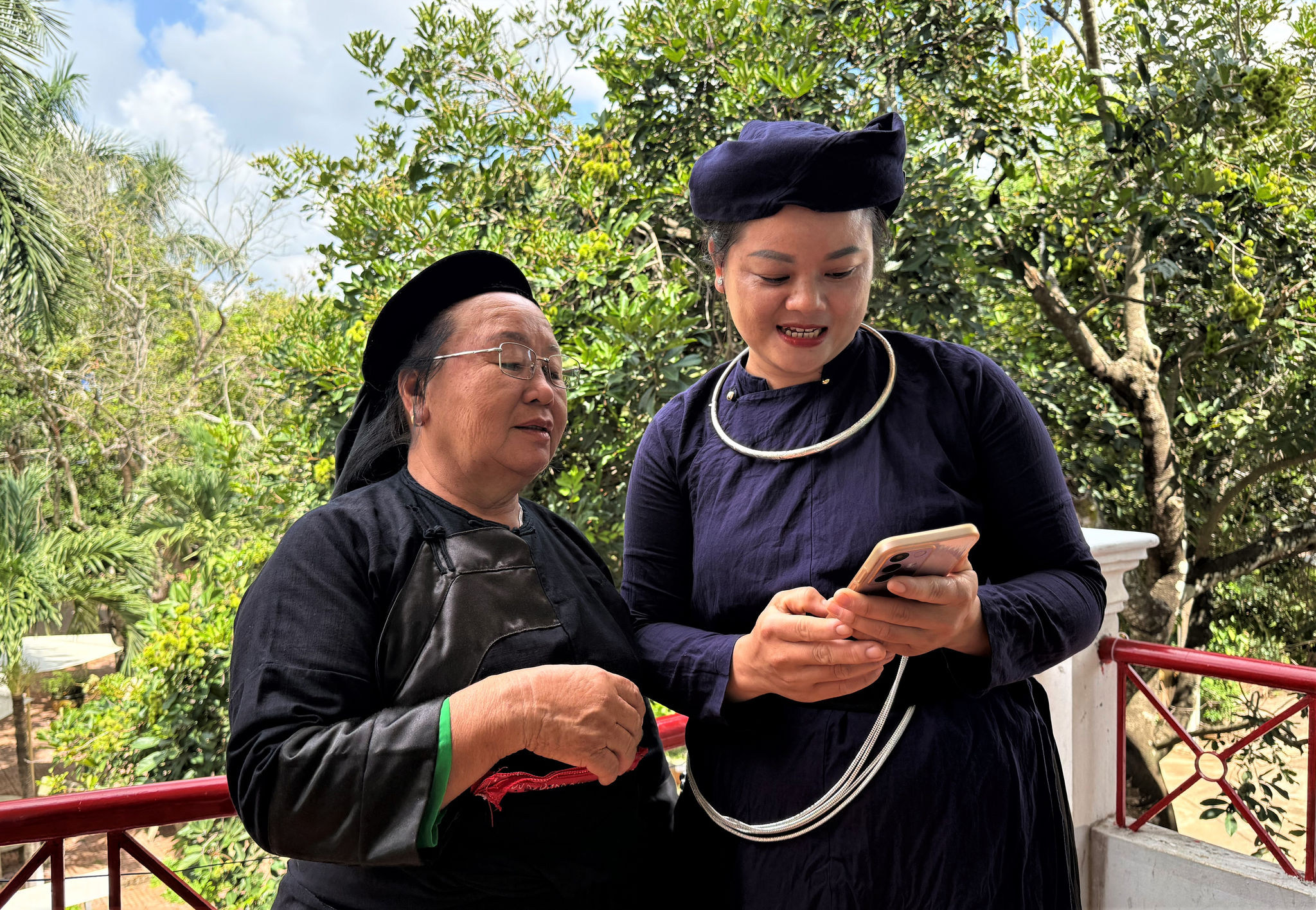 Chị Nông Thị Ngon (bên phải), Người có uy tín xã Ea Kly đến từng hộ gia đình hướng dẫn người dân sử dụng điện thoại thông minh, cài đặt ứng dụng VNeID