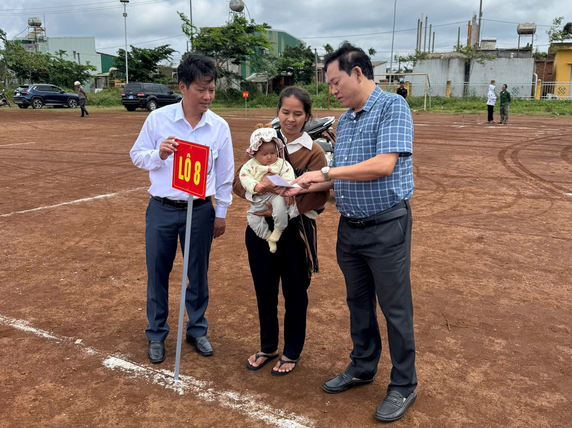 Chủ tịch UBND xã Krông Năng Lê Hồng Văn (bên phải) chúc mừng, động viên hộ dân vừa bốc thăm đất ở