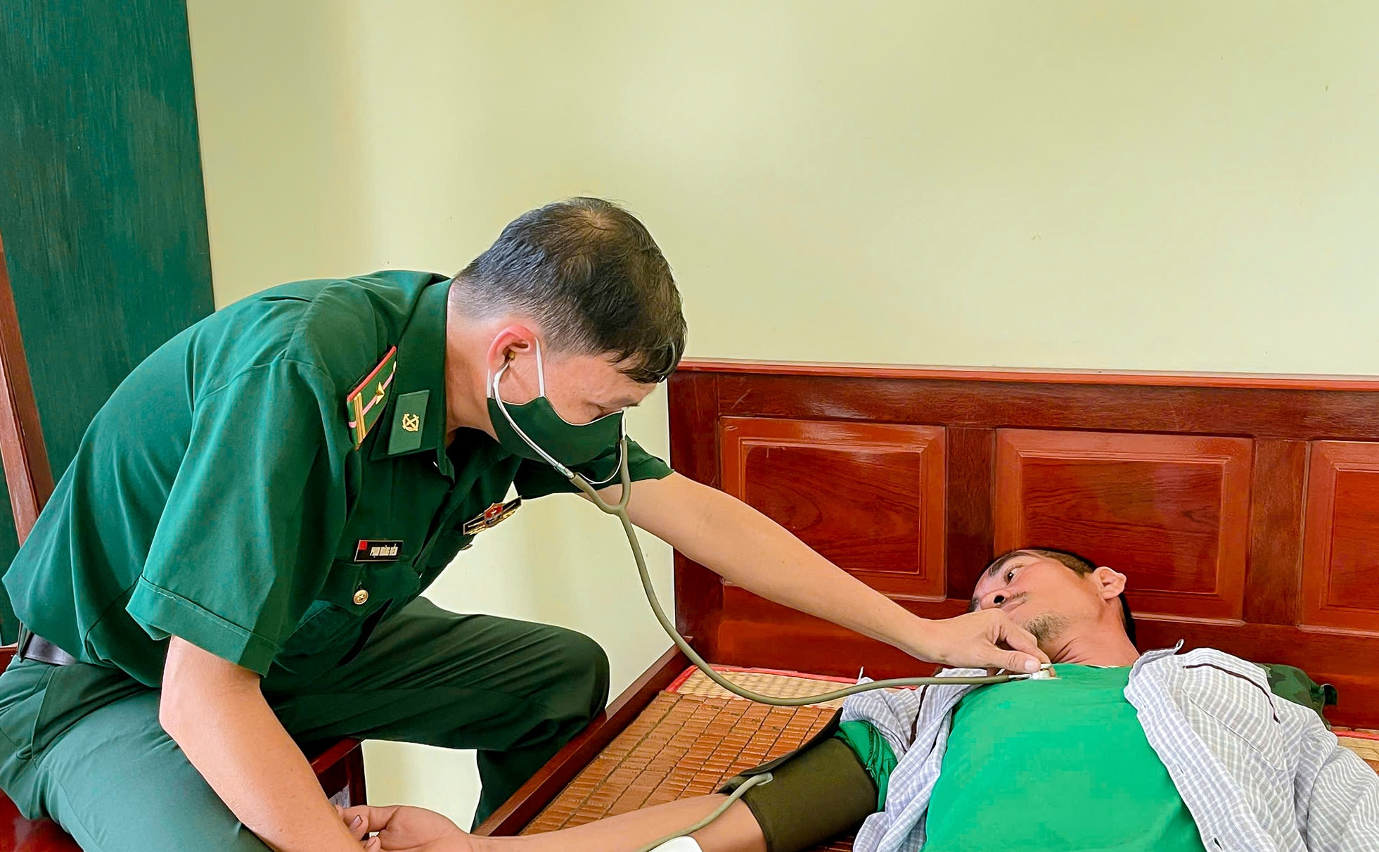 Quân y đồn Biên phòng Trung Bình thăm khám sức khỏe cho ông Lê Văn Ngoan. Ảnh: Văn Long