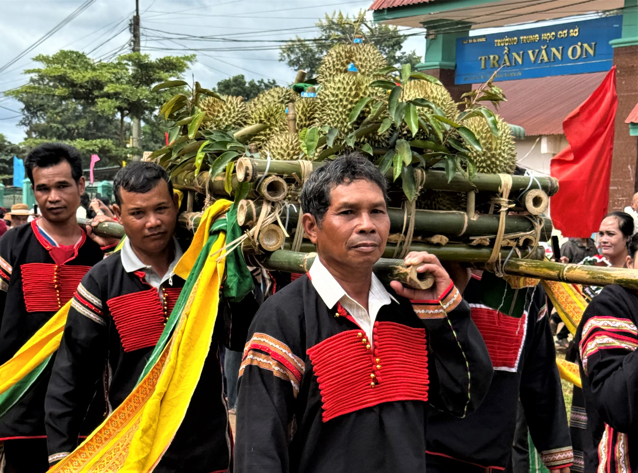 Thanh niên đại diện cộng đồng các dân tộc trên địa bàn xã Ea Knuếc trang trọng rước kiệu sầu riêng từ khu vực cây cổ thụ về sân khấu chính.
