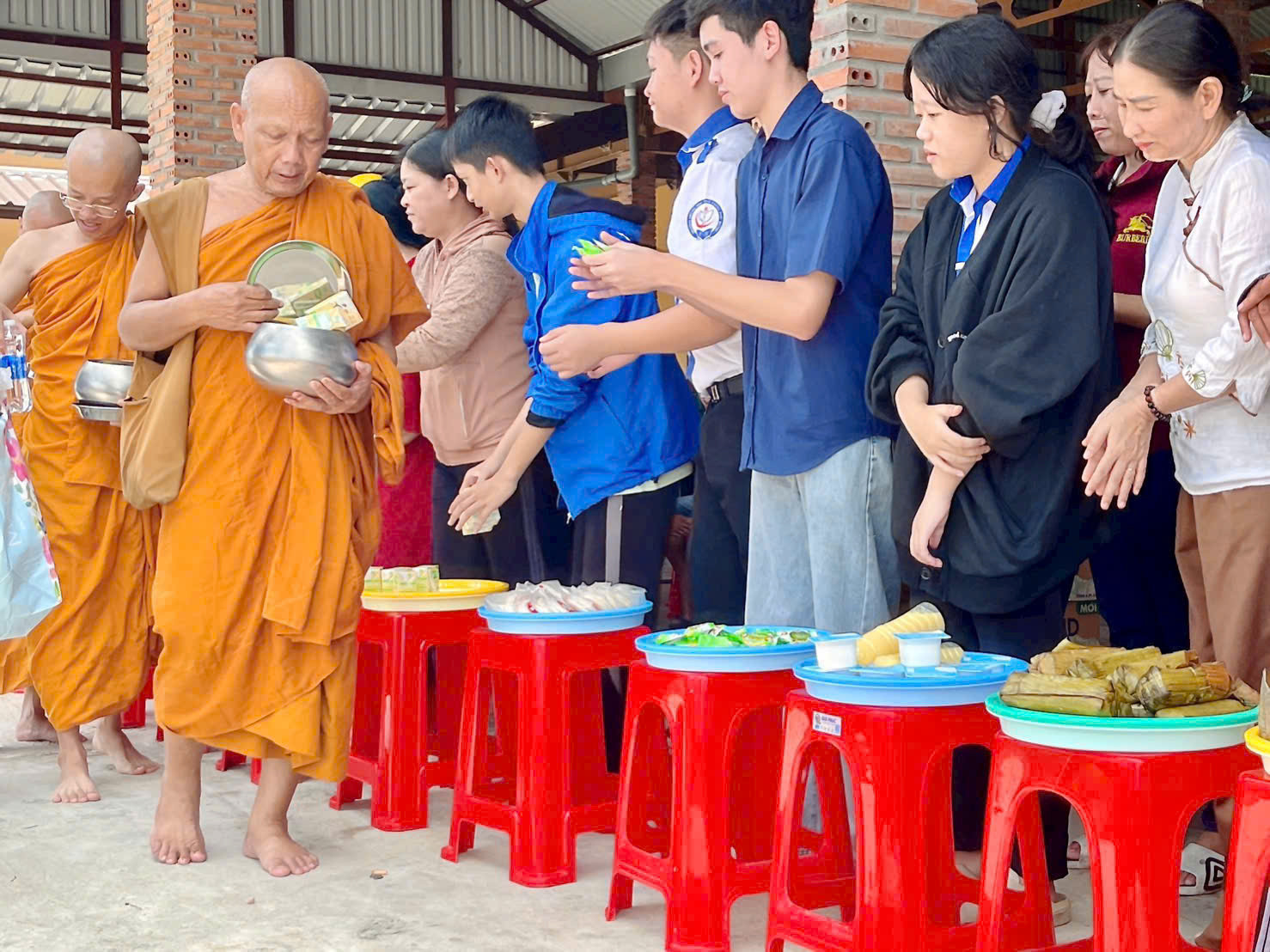 Hoà thượng Thạch Hà, trong thực hành khất thực, tạo cơ hội cho phật tử biết cho đi, thực hành sự bố thí và hướng lòng tri ân. Ảnh Song Vy