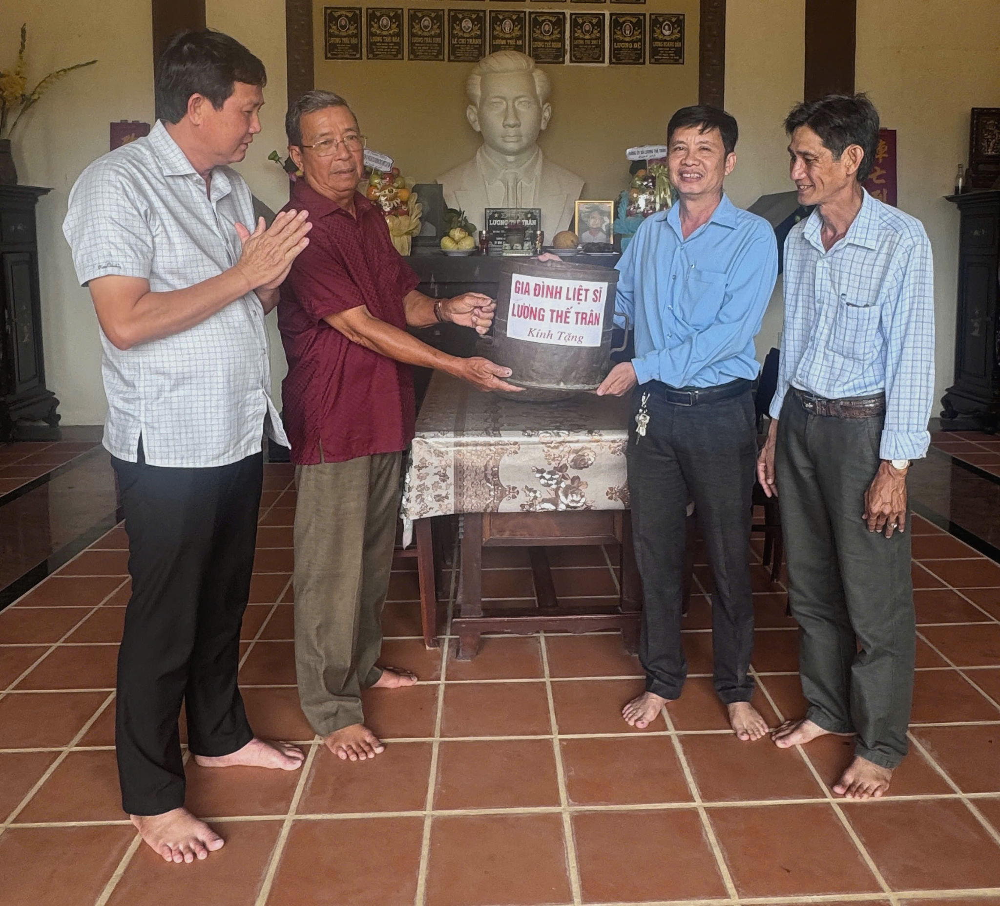 Trương Thành Tài (thứ hai bên trái), đại diện gia đình liệt sĩ Lương Thế Trân trao hiện vật cho ông Lê Hoà Hiệp. Ảnh: Như Tâm