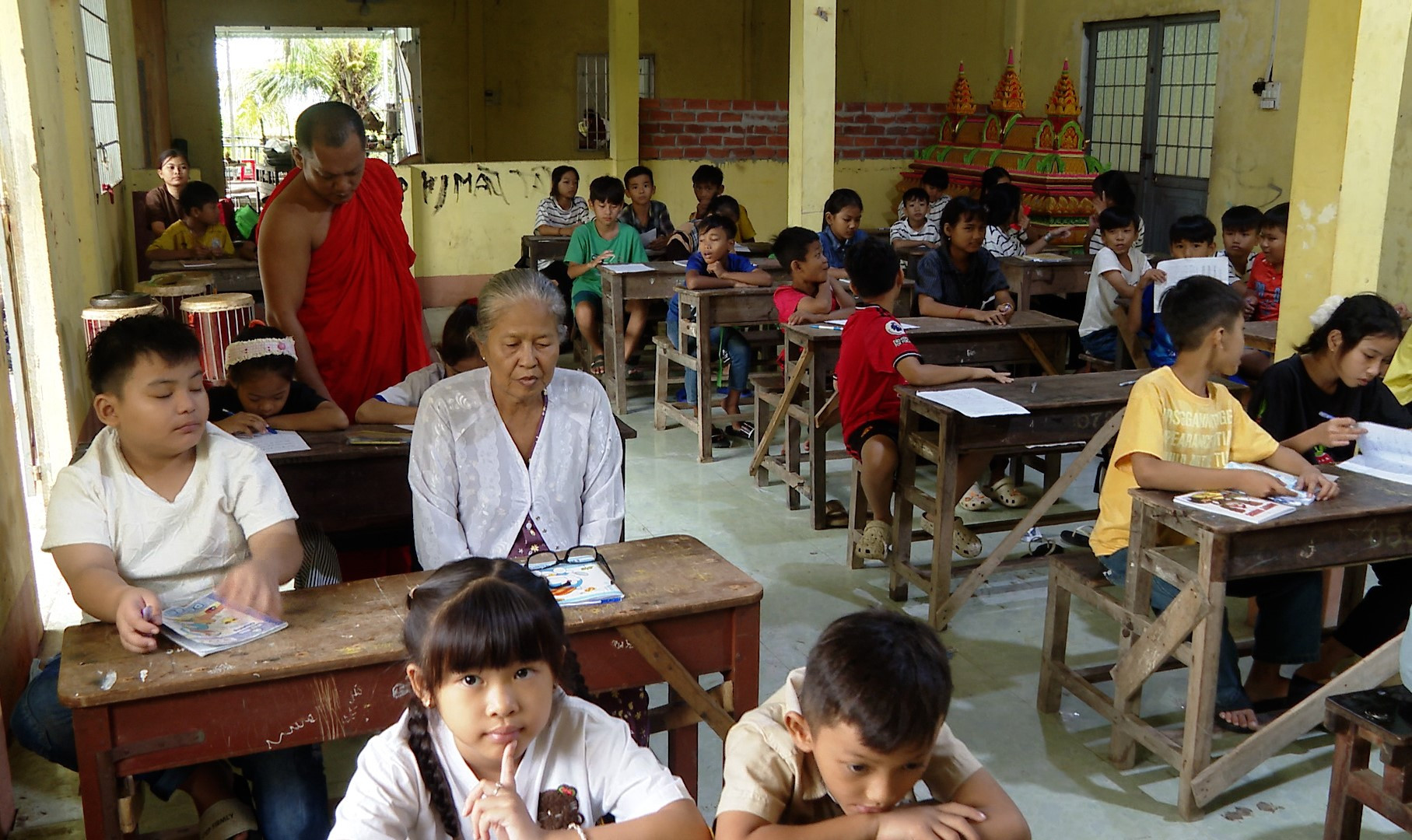 Bà Sơn Thị Phấn chăm chú nghe giảng và viết chữ trong lớp học chữ Khmer hè tại chùa Cos Đôn, xã Vĩnh Phước, tỉnh Cà Mau