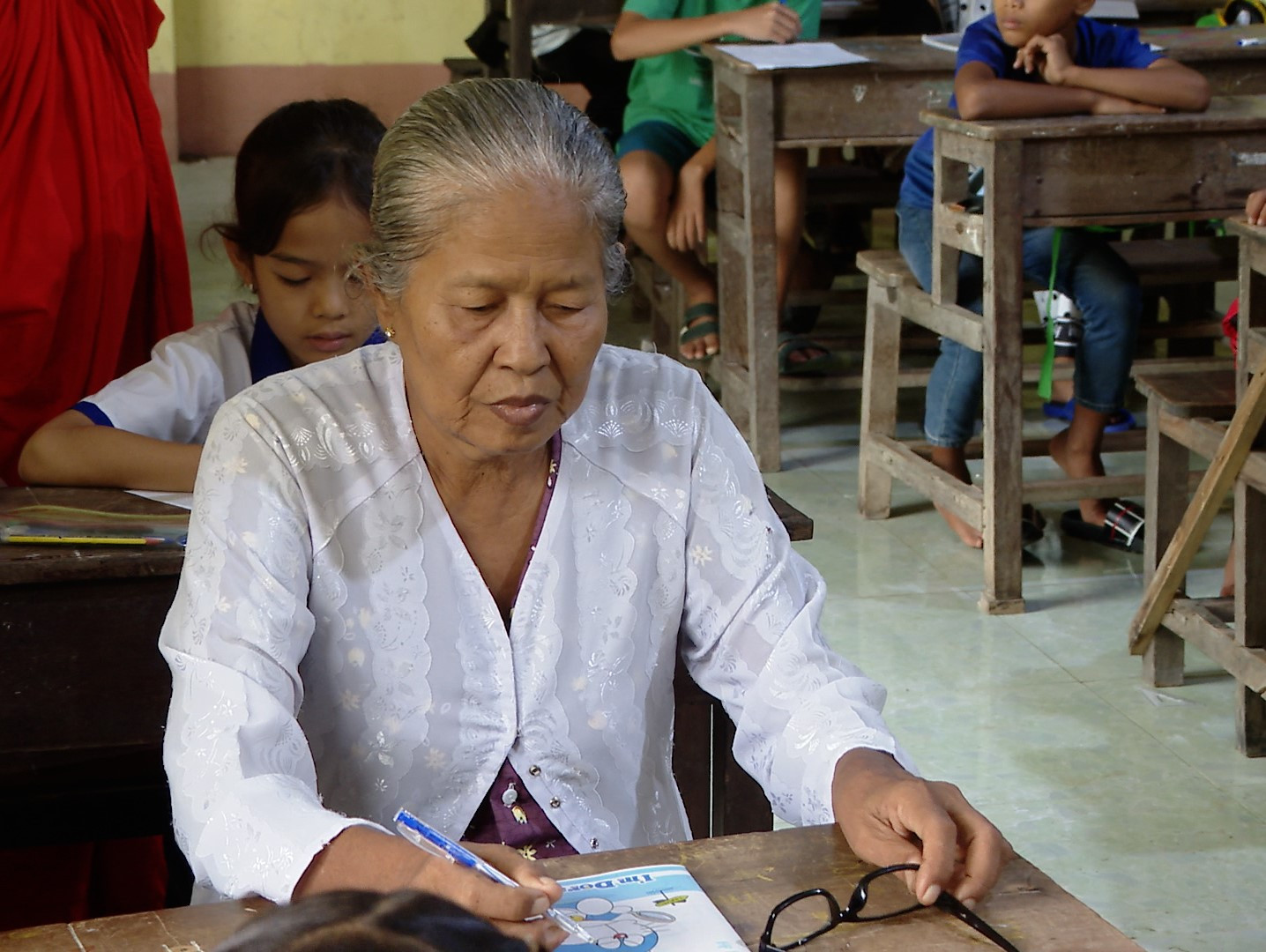 Bà Sơn Thị Phấn chăm chú nghe giảng và viết chữ trong lớp học chữ Khmer hè tại chùa Cos Đôn, xã Vĩnh Phước, tỉnh Cà Mau (2)