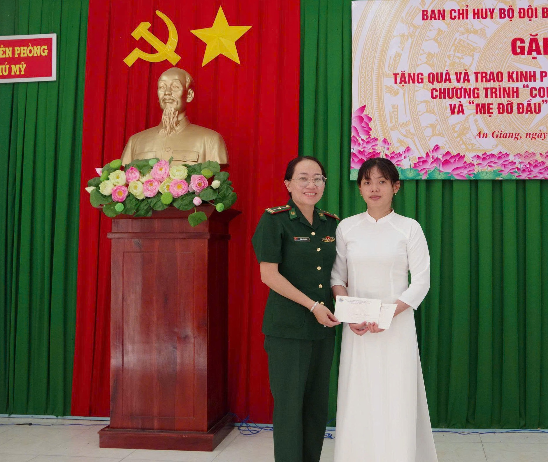 Thiếu tá Lâm Thị Thu Ngân, trao quà và học bổng cho em Trần Lê Tường Vi - thuộc Chương trình ' Mẹ đỡ đầu'. Ảnh. Song Vy