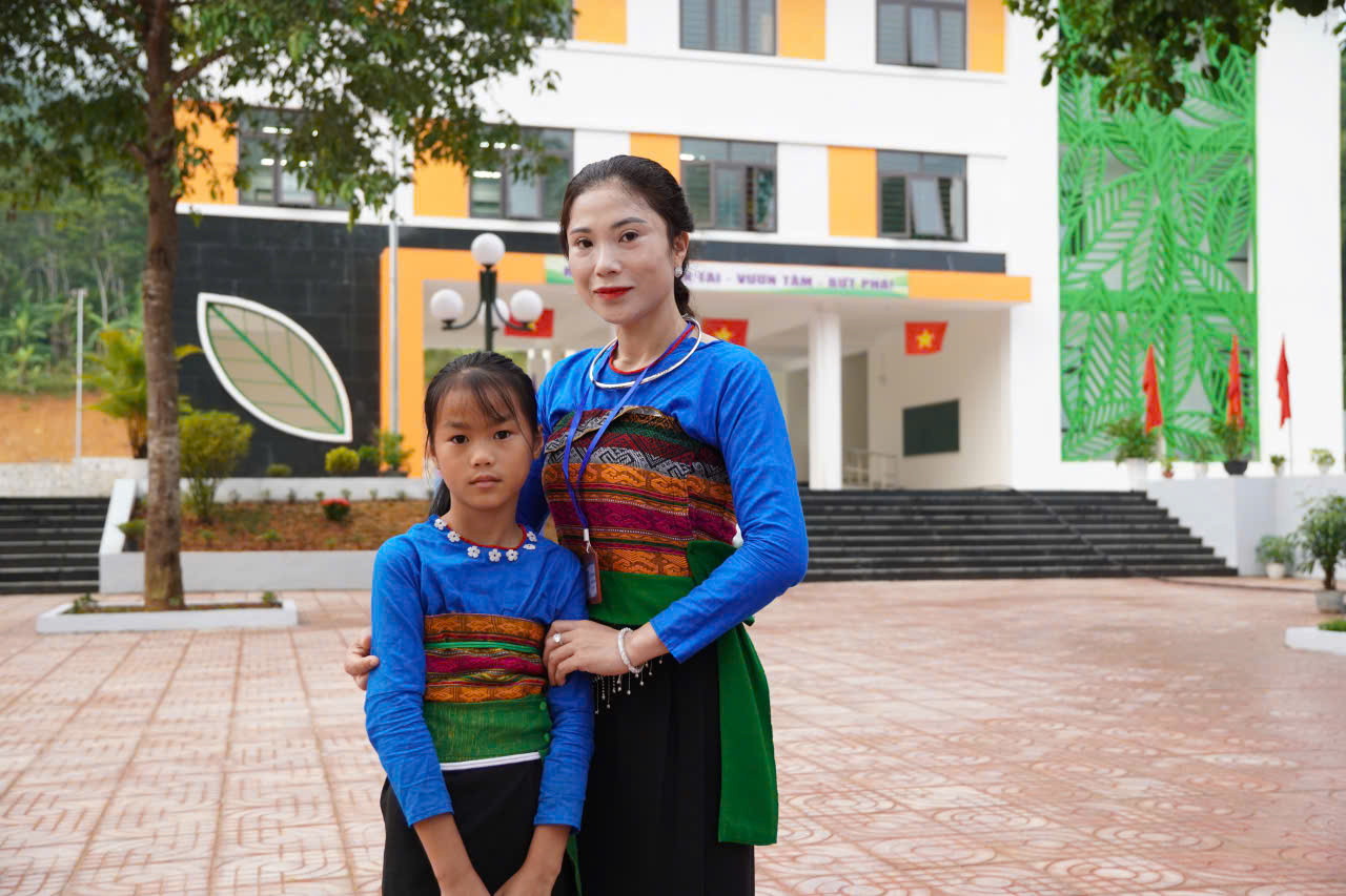 Cô giáo Hoàng Thị Hà vui mừng đón học sinh tại ngôi trường mới.