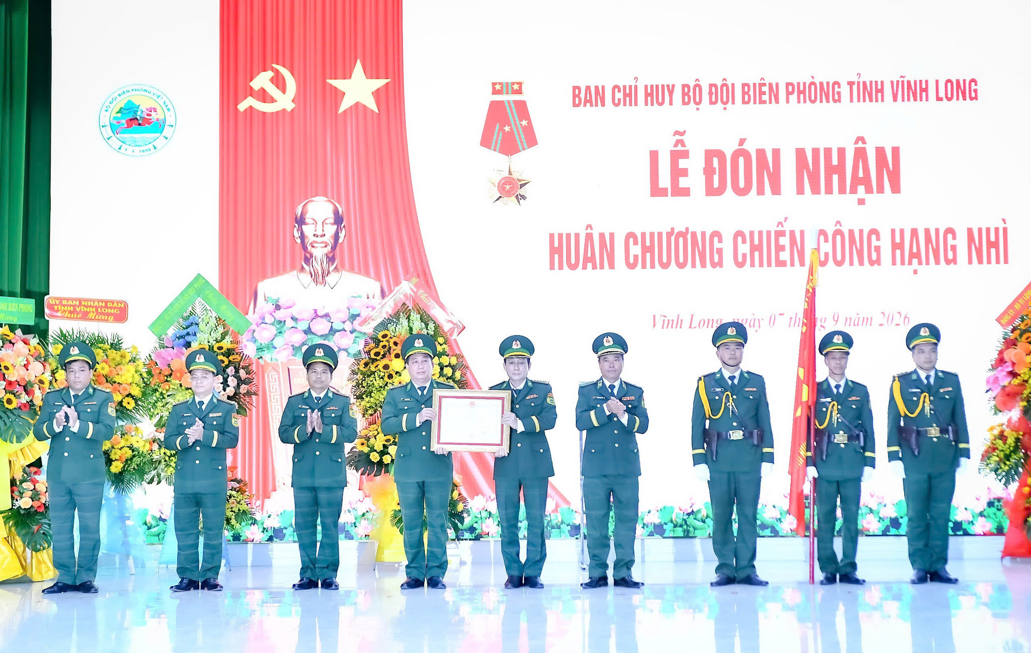 Thừa ủy quyền của Chủ tịch nước, Thiếu tướng Trần Ngọc Hữu, Phó Tư lệnh Bộ đội Biên phòng gắn Huân chương Chiến công hạng Nhì lên quân kỳ Quyết thắng Bộ đội Biên phòng tỉnh Vĩnh Long. Ảnh: Như Tâm
