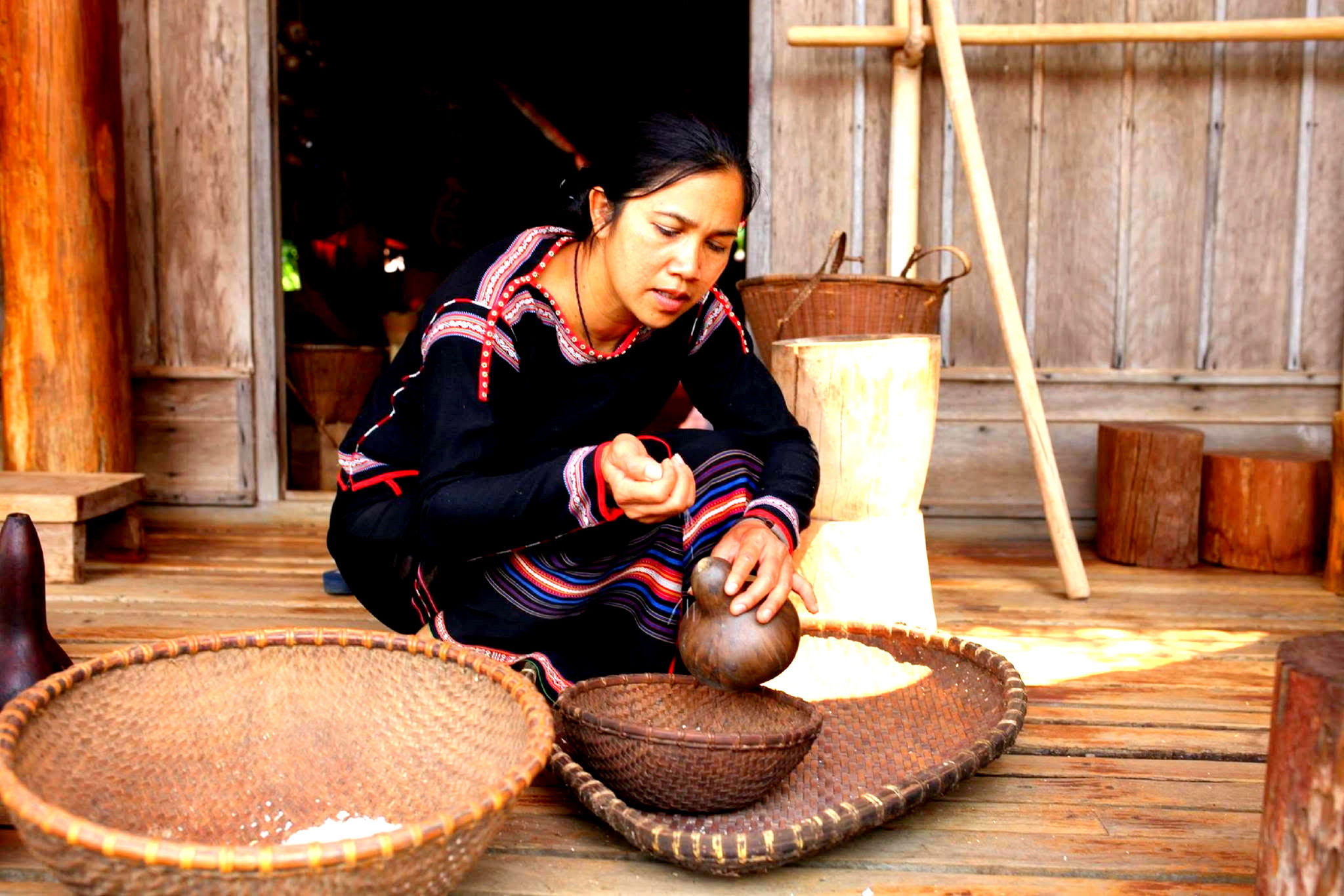 H’len Niê giã gạo bên khung cửa nhà dài ở Akô Dhông.