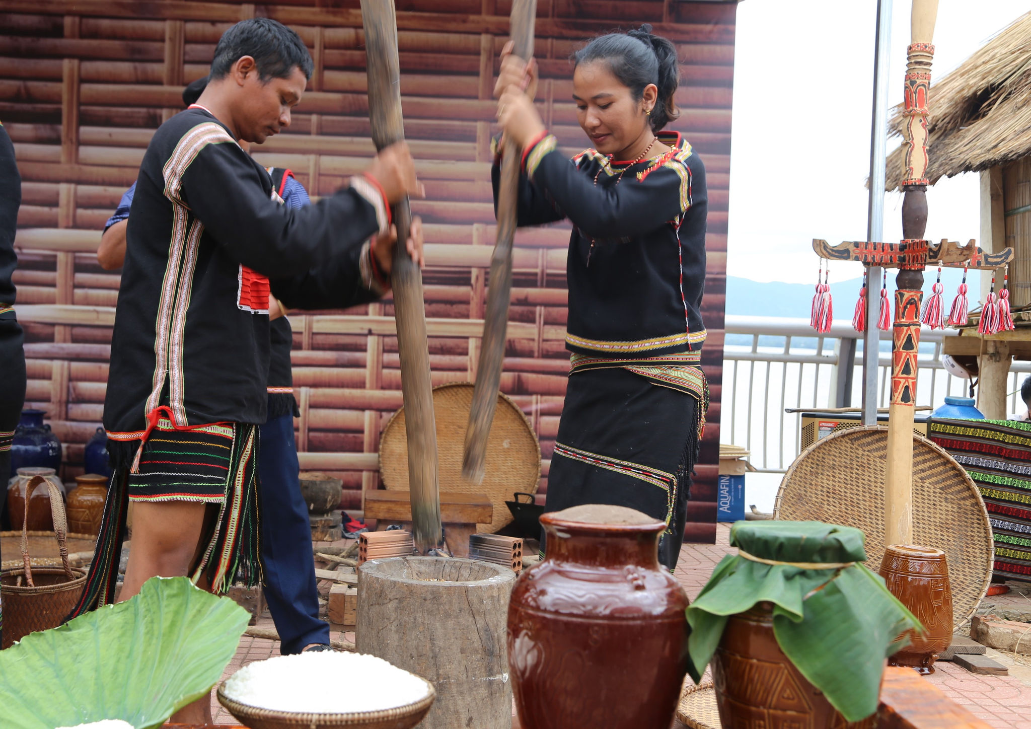 Sau khi rang lúa, người làm rượu giã gạo để nấu cơm