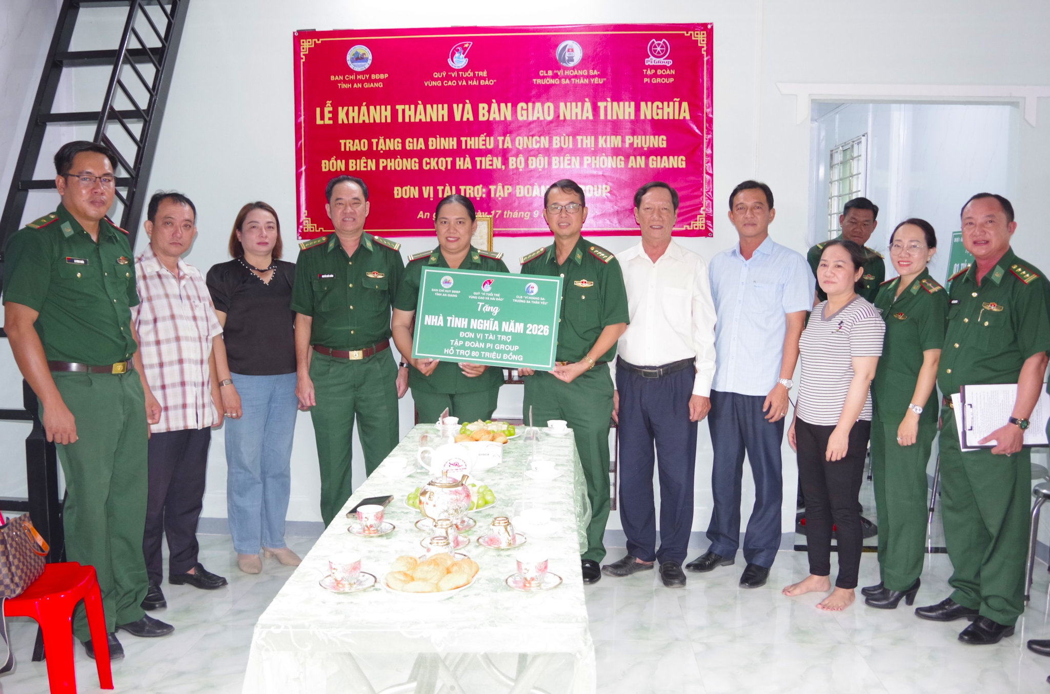 Thủ trưởng Cục Chính trị BĐBP và Ban Chỉ huy BĐBP tỉnh An Giang trao bảng hỗ trợ kinh phí xây dựng nhà của các đơn vị tài chợ cho đồng chí Bùi Thị Kim Phụng. Ảnh: Lê Khoa