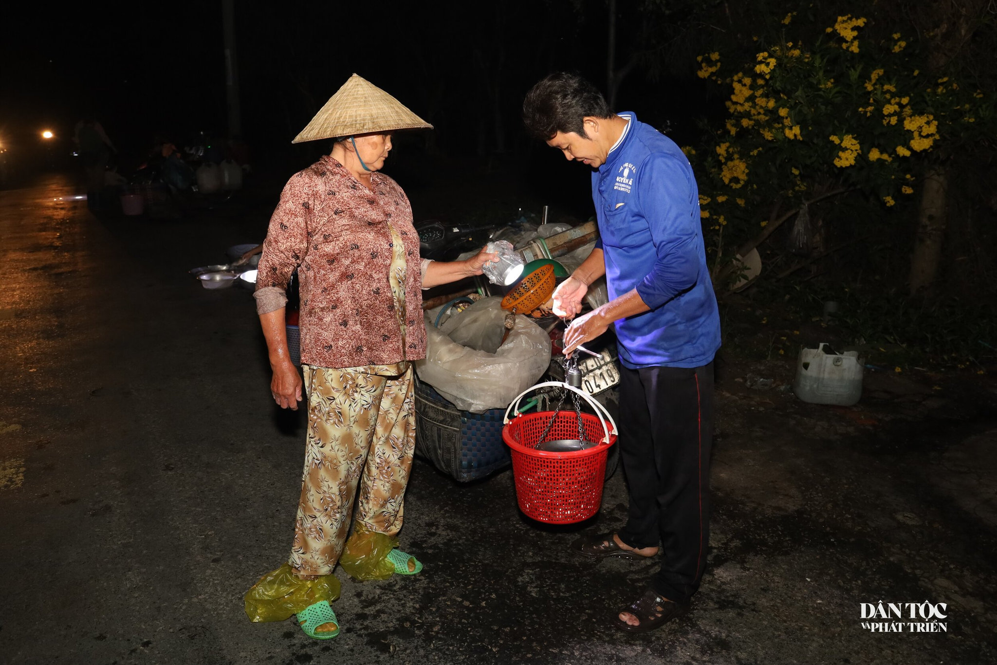 Trong bóng tối mờ ảo, ánh sáng le lói từ đèn pin trên đầu người bán và người mua là nguồn sáng duy nhất giúp họ soi cá, cân lựa và mua bán hàng hóa. Điều ngạc nhiên là cả người mua và người bán đều sử dụng cân tiểu ly truyền thống. 