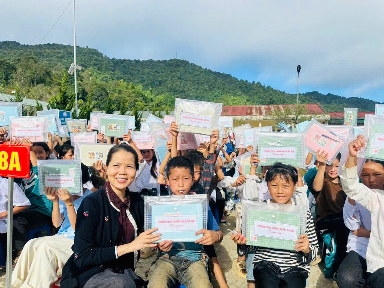 Cô Nguyễn Thanh Huyền, Bí thư Đảng ủy, Hiệu trưởng Trường THCS Thanh Xuân, trao quà cho học sinh Trường TH&THCS DTNT Làng Mô. Ảnh: CSCC