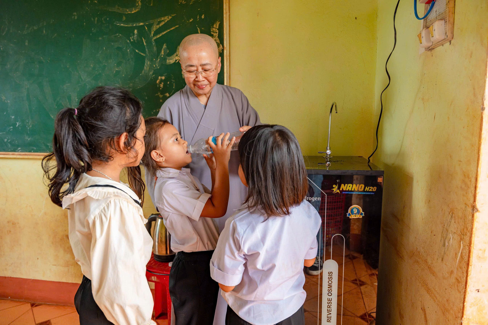 Học sinh uống nước từ máy lọc nước được trang bị tại điểm trường làng Or. Ảnh Ngọc Duy