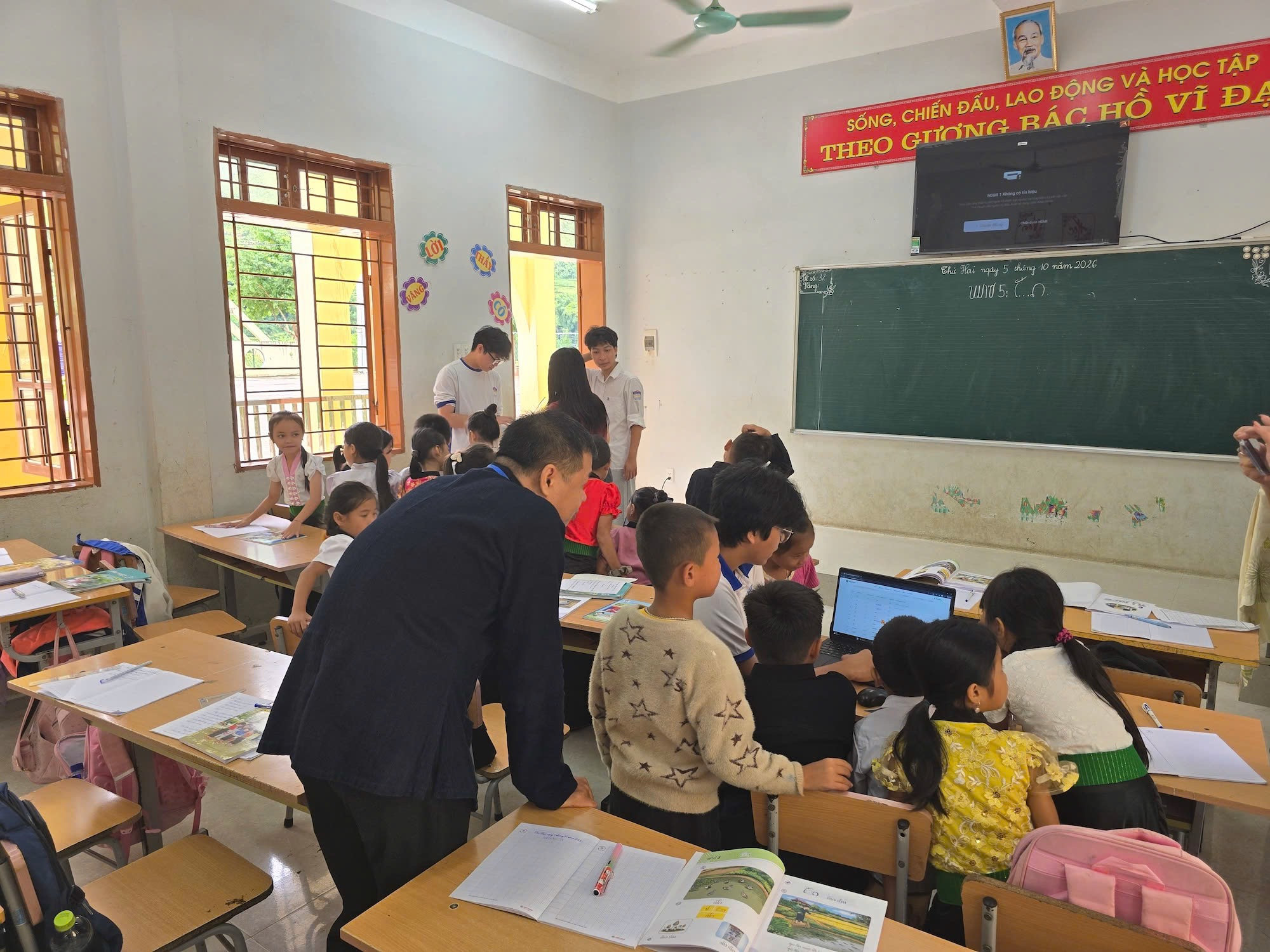 Các thành viên tham gia buổi học tiếng Thái của học sinh trường Nậm Păm và hướng dẫn sử dụng phần mềm. Ảnh: Việt Hà