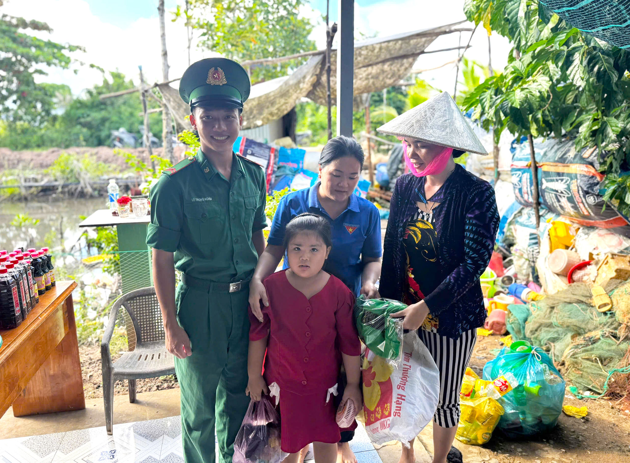 Cán bộ, chiến sĩ Đồn Biên phòng Rạch Gốc và Đoàn thanh niên địa phương đổi quà lấy rác cho người dân. Ảnh: Hoàng Tá