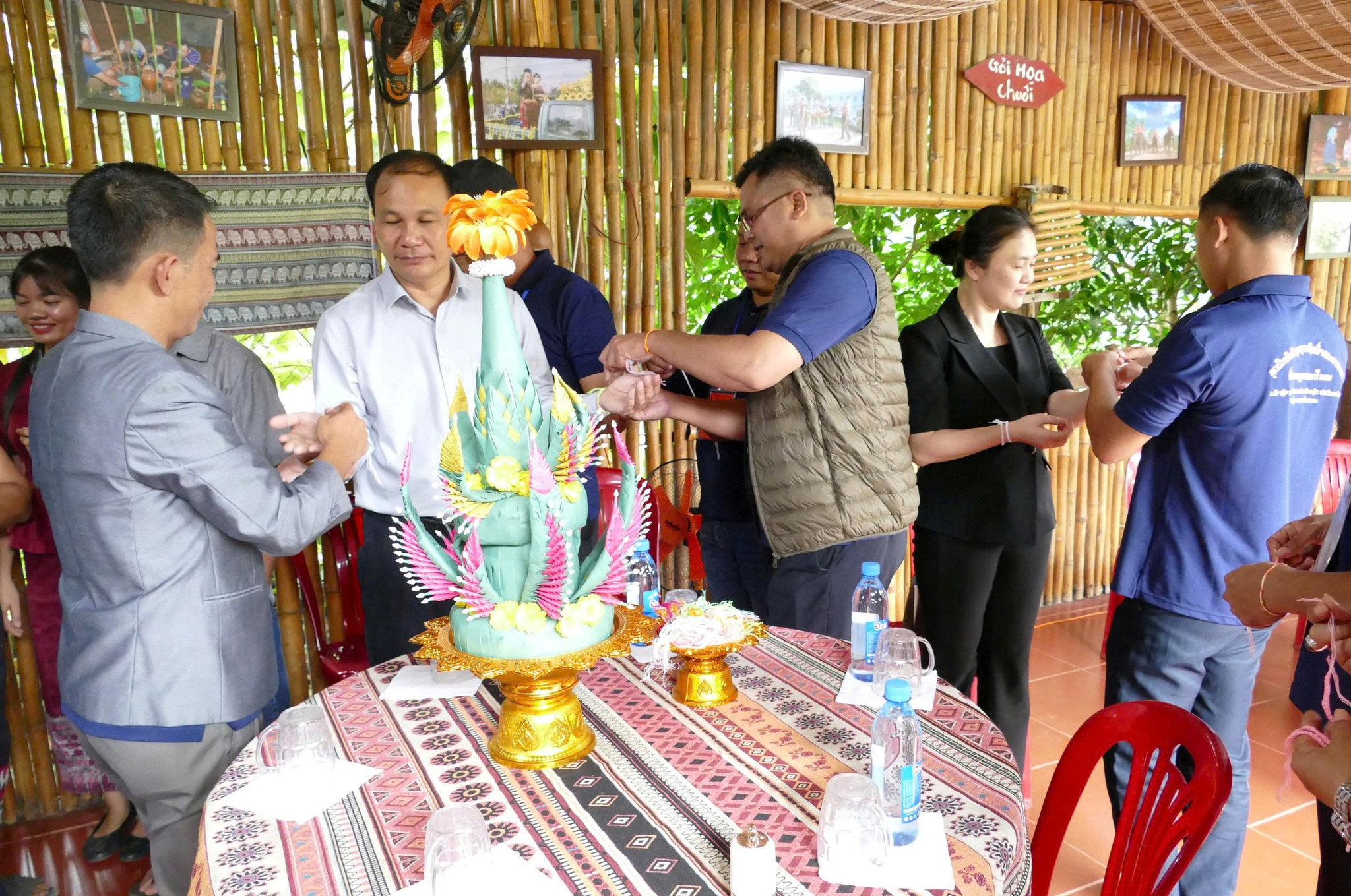 Người Lào ở Buôn Đôn thực hiện nghi thức buộc chỉ cổ tay cho thành viên đoàn công tác