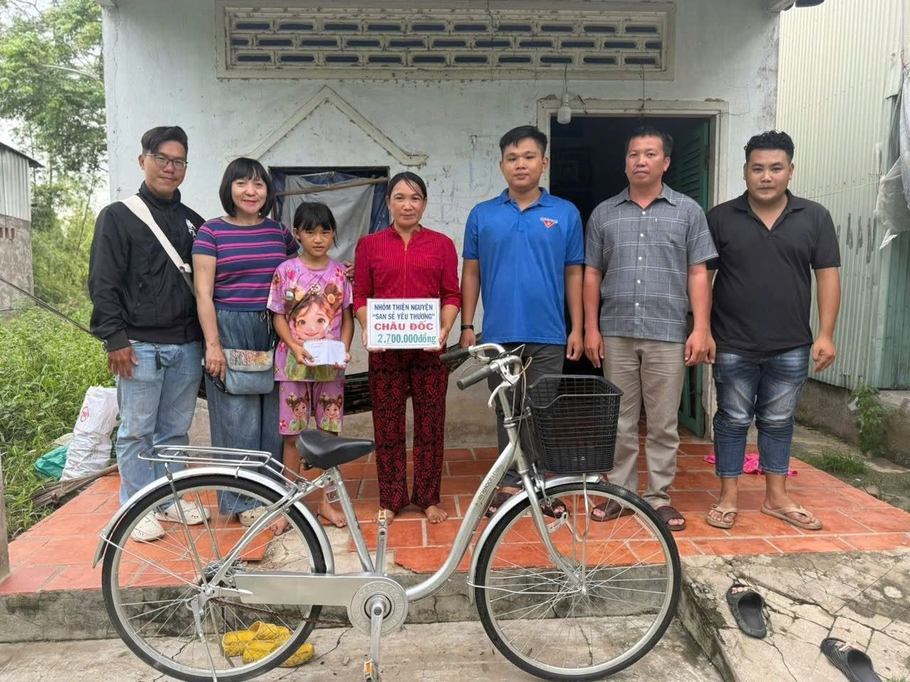 Các mạnh thường quân trao quà đến trẻ em gái vượt khó học giỏi. Trong ảnh: cháu Nguyễn Thị Thảo ấp Văn Râu được trao xe đạp và học bổng