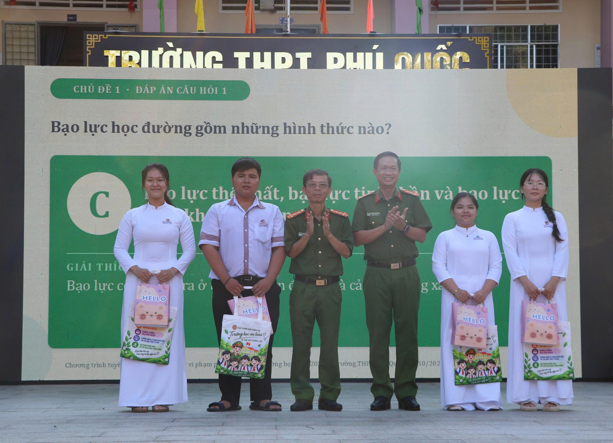 Đại tá Nguyễn Nhật Trường ( đứng thứ 3 bên phải), Phó Giám đốc Công an tỉnh An Giang và Đại tá Nguyễn Chí Nguyện, Trưởng phòng Cảnh sát hình sự trao quà cho các em học sinh trường THPT Phú Quốc